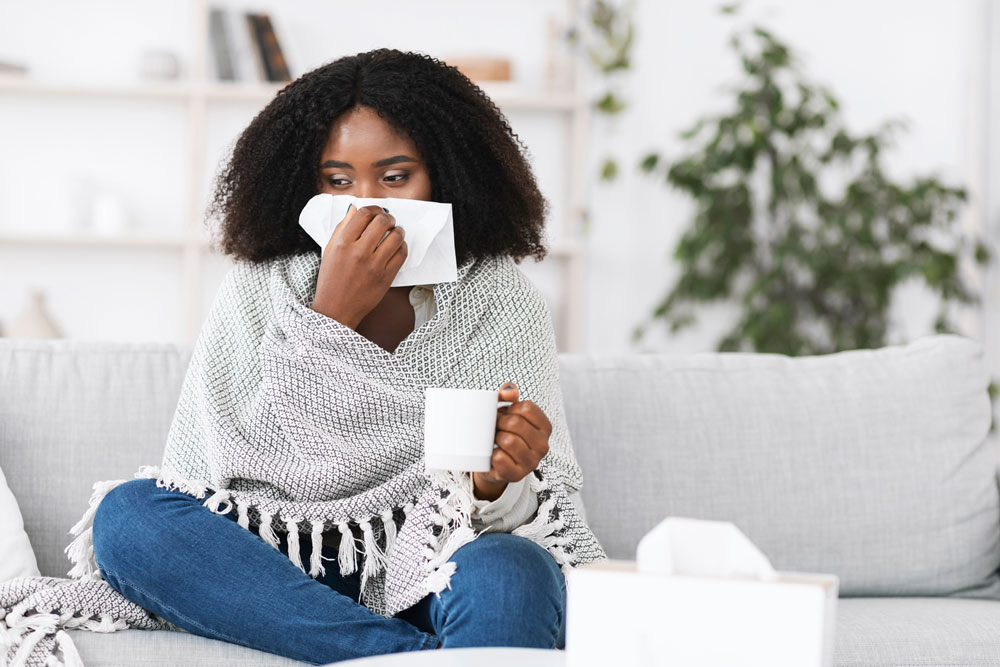 Woman on sofa with tissues