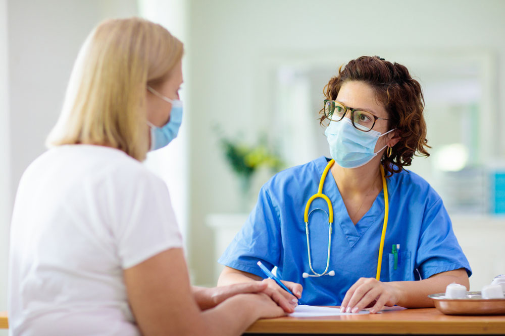 doctor in blue scrubs with stethoscope talking with doctor