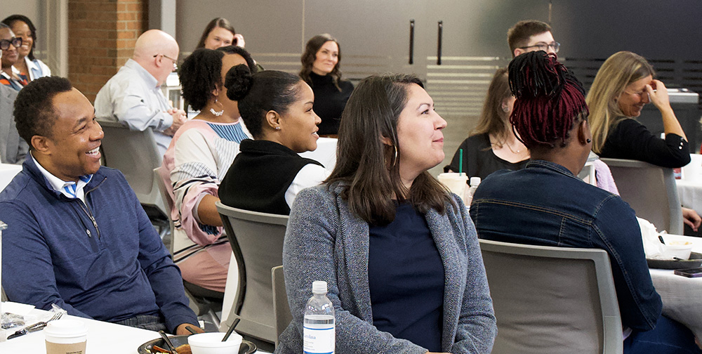 Blue Cross employees listening to a presentation at a work event