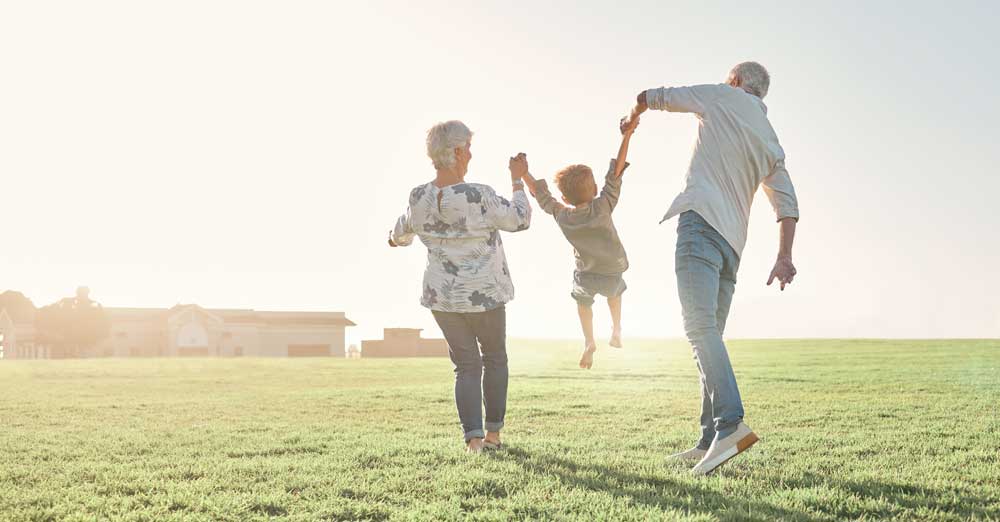 Older woman and man in field with little boy
